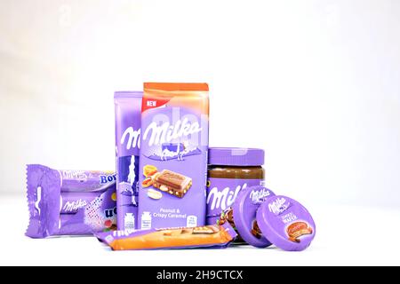 KHARKOV, UKRAINE - JULY 2, 2021: Milka chocolate products with classical lilac color wrapping design on white wooden table Stock Photo