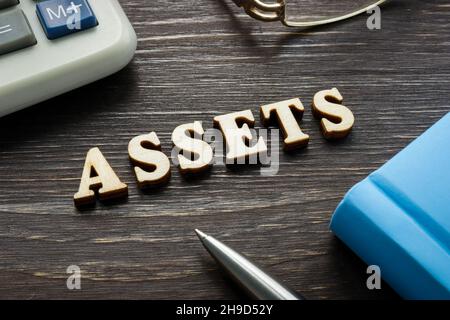 Word assets from wooden letters on the desk. Stock Photo