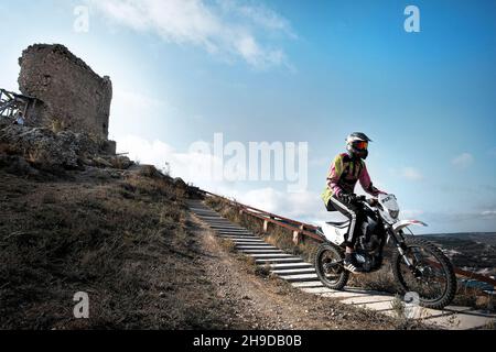 Crimea. Balaklava.October 2010. View of the bay from the mountain. Fortress. Motocross. Two motorcyclists drive down the mountain. Close-up Stock Photo