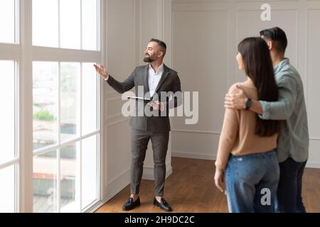 Real Estate Agent Showing Young Buyers New Property Stock Photo