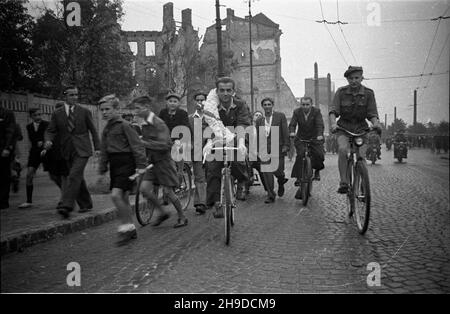 Warszawa, 1947-09-28. Pierwszy powojenny Wyœcig Kolarski Dooko³a Polski na trasie Kraków–Warszawa (VI Tour de Pologne). Nz. udekorowany wieñcem zwyciêzca ca³ego wyœcigu - Stanis³aw Grzelak (C) z klubu Tramwajarz £ódŸ, podczas rundy honorowej ulicami zniszczonej stolicy.  bk/ppr  PAP      Warsaw, Sept. 28, 1947. Stadium of the Legia military sports club. The first cycling race around Poland after the war (VI Tour de Pologne) from Cracow to Warsaw. Pictured: winner of the race  Stanisaw Grzelak from Tramwajarz Lodz club doing a lap of honour.  bk/mgs  PAP Stock Photo