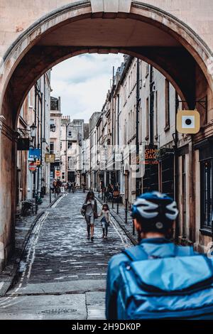 Queen Street, Bath. The narrow cobbled lane, sits under a characterful stone arched building. Stock Photo