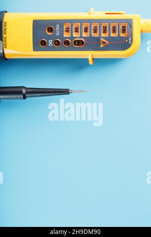 Two-pole voltage indicator close-up on a blue background. Testing and verification of electrical networks Stock Photo