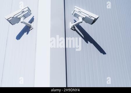 CCTV camera on the wall of the building for monitoring and protection. Total security control system concept. Stock Photo