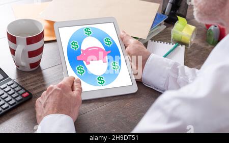 Saving money concept shown on a tablet held by a man Stock Photo