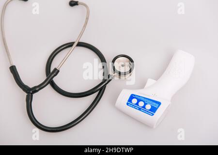 Stethoscope, pulse oximeter and thermometer gun on white background. Phonendoscope. Infrared isometric thermometer gun to check body temperature for Stock Photo