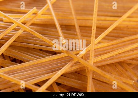 Raw whole wheat spaghetti bunch. Macro. Dry integral food. Brown organic pasta Stock Photo