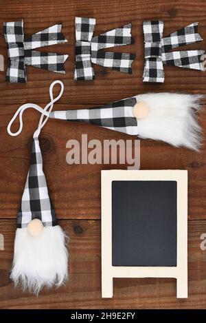 Christmas Flat Lat - an arrangement of Gnome ornaments and bows in black and white plaid and a blank chalkboard for your copy. Stock Photo