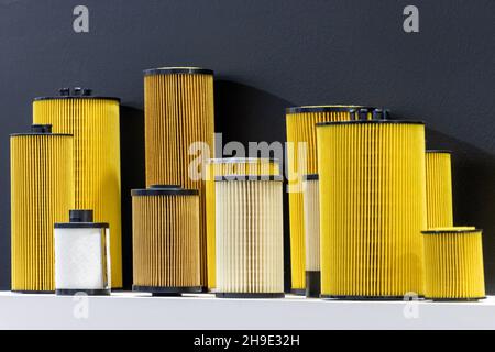 Car engine oil filters in various sizes. Isolated black background Stock Photo