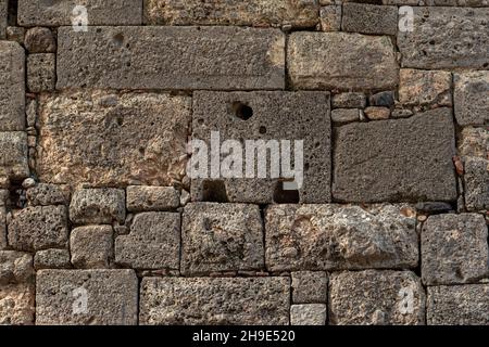 background - antique stone wall made of huge blocks of various sizes and shapes Stock Photo