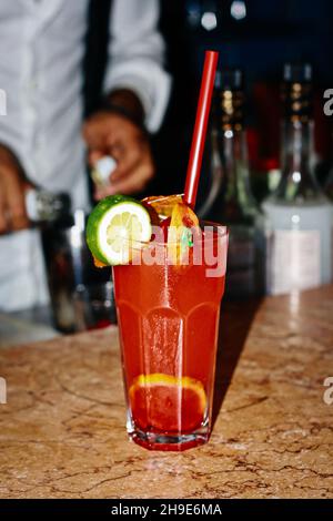 Red drink with strawberry lime ice. Bartendeer prepared cocktail with campari aperol gin Stock Photo