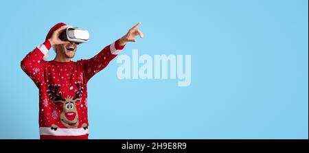 Virtual Party. Excited Man In Vr Glasses And Christmas Sweater Pointing Away Stock Photo