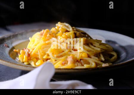 Creamy Italian cuisine spaghetti alla carbonara with creamed corn and bacon Stock Photo