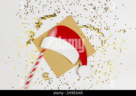 Santa Claus paper hat with golden confetti and stars isolated on white background. Stock Photo