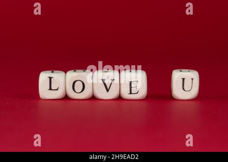 Wooden cubes with the words LOVE YOU on a red background. Valentine's Day concept Stock Photo