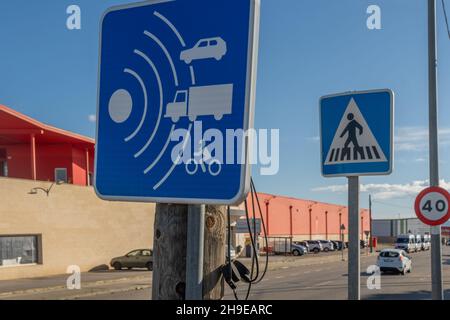 Blue speed control sign for vehicles on the street. In the background, out of focus, a vehicle circulating Stock Photo