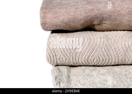Stack of pastel color winter knitted sweaters background. Cozy Autumn and winter concept close up image. Stock Photo