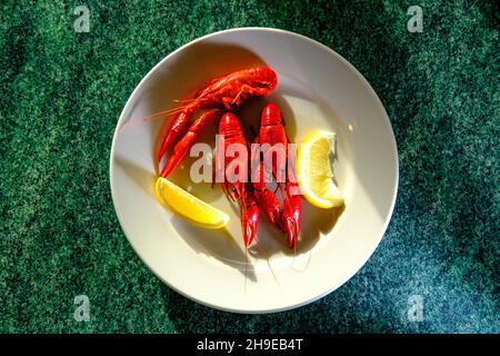 Boiled buttery crayfish seafood dinner served with lemon wedges Stock Photo