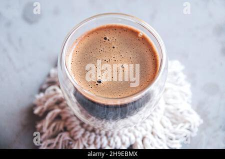 Hot coffee in double walled glass on gray background Stock Photo