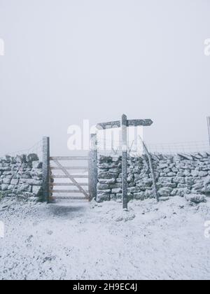 Pen-Y-Ghent, Yorkshire Dales, UK. 6th December, 2021. Snow and whiteout conditions next to the Pennine Bridleway footpath leading up to the summit of Pen-Y-Ghent in the Yorkshire Dales. Credit: Ed Clews/Alamy Live News Stock Photo