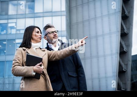 Business people looking away and bringing new business ideas in to life - Two workers standing and discussion about work outside office,teamwork, work Stock Photo