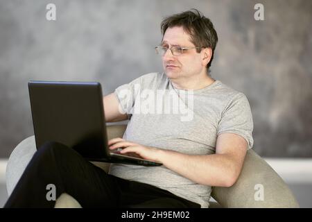 Presbyopia in 52 year old man working from home during lockdown due to coronavirus. Stock Photo
