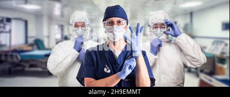 Team of Female and Male Doctors or Nurses Wearing Personal Protective Equiment In Hospital Emergency Room. Stock Photo