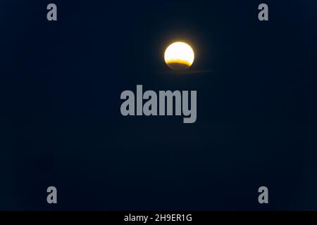Moon during partial lunar eclipse over Tauranga in black night sky Stock Photo