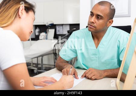 Doctor cosmetologist working with female client in clinic Stock Photo
