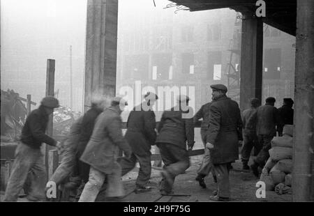 Warszawa, 1948-01. Pl. Trzech Krzy¿y. Budowa siedziby Ministerstwa Przemys³u i Handlu. Gmach wg projektu Stanis³awa Rych³owskiego i Stanis³awa Bieñkuñskiego wznoszono w latach 1946-48. W konstrukcji budynku zastosowano nowatorskie rozwi¹zania, m.in. pustaki produkowane na miejscu z mielonego gruzu (tzw. gruzobeton). Nz. brygada cieœli uczestnicz¹cych we wspó³zawodnictwie pracy biegnie na stanowiska. po/mgs  PAP    Dok³adny dzieñ wydarzenia nieustalony.      Warsaw, Jan., 1948. Three Crosses Square. Building of Industry and Trade Ministry HQ. The buiding designed by Stanislaw Rychlowski and Sta Stock Photo