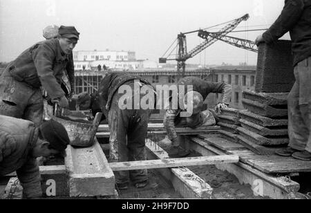 Warszawa, 1948-01. Pl. Trzech Krzy¿y. Budowa siedziby Ministerstwa Przemys³u i Handlu. Gmach wg projektu Stanis³awa Rych³owskiego i Stanis³awa Bieñkuñskiego wznoszono w latach 1946-48. W konstrukcji budynku zastosowano nowatorskie rozwi¹zania, m.in. pustaki produkowane na miejscu z mielonego gruzu (tzw. gruzobeton). Nz. murarze uk³adaj¹ gruzobetonowe wype³nienie stropu. po/mgs  PAP    Dok³adny dzieñ wydarzenia nieustalony.      Warsaw, Jan., 1948. Three Crosses Square. Building of Industry and Trade Ministry HQ. The buiding designed by Stanislaw Rychlowski and Stanislawa Bienkunski was constru Stock Photo