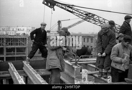 Warszawa, 1948-01. Pl. Trzech Krzy¿y. Budowa siedziby Ministerstwa Przemys³u i Handlu. Gmach wg projektu Stanis³awa Rych³owskiego i Stanis³awa Bieñkuñskiego wznoszono w latach 1946-48. W konstrukcji budynku zastosowano nowatorskie rozwi¹zania, m.in. pustaki produkowane na miejscu z mielonego gruzu (tzw. gruzobeton). Nz. robotnicy uk³adaj¹ ¿elbetowe belki stropowe. po/mgs  PAP    Dok³adny dzieñ wydarzenia nieustalony.      Warsaw, Jan., 1948. Three Crosses Square. Building of Industry and Trade Ministry HQ. The buiding designed by Stanislaw Rychlowski and Stanislawa Bienkunski was constructed i Stock Photo