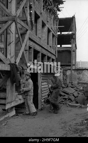 Warszawa, 1948-01. Pl. Trzech Krzy¿y. Budowa siedziby Ministerstwa Przemys³u i Handlu. Gmach wg projektu Stanis³awa Rych³owskiego i Stanis³awa Bieñkuñskiego wznoszono w latach 1946-48. W konstrukcji budynku zastosowano nowatorskie rozwi¹zania, m.in. pustaki produkowane na miejscu z mielonego gruzu (tzw. gruzobeton). Nz. robotnicy nosz¹ p³yty z gruzobetonu do windy.  po/mgs  PAP    Dok³adny dzieñ wydarzenia nieustalony.      Warsaw, Jan., 1948. Three Crosses Square. Building of Industry and Trade Ministry HQ. The buiding designed by Stanislaw Rychlowski and Stanislawa Bienkunski was constructed Stock Photo