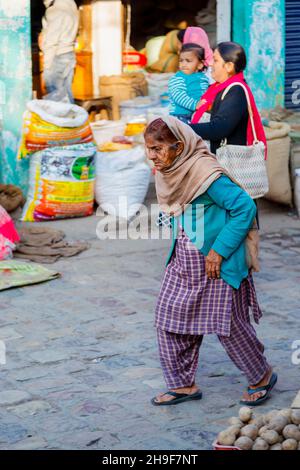 Wrinkled local Indian old woman wearing typical local dress walking in a street in Pragpur heritage village, Kagra district, Himachal Pradesh, India Stock Photo