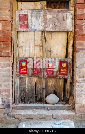 Dilapidated old wooden door in the crumbling wall of a building in Pragpur, a heritage village in Kagra district, Himachal Pradesh, India Stock Photo