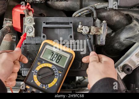 Checking car battery voltage on a car, dead battery Stock Photo