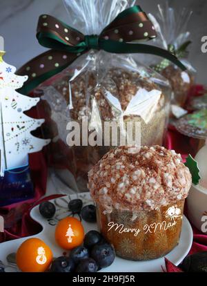 Delicious Panettone Italian tasty dessert with snowman cupcake and 3d greeting cards of Christmas trees Stock Photo