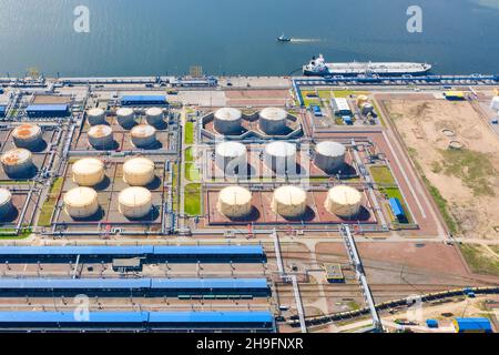 Aerial view of oil tankers moored at an oil storage silo terminal port and railway road infrastructure ground Stock Photo