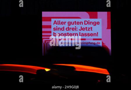 Dresden, Germany. 07th Dec, 2021. Cars drive past an LED wall advertising the booster vaccination against Covid-19 in the morning. Credit: Robert Michael/dpa-Zentralbild/dpa/Alamy Live News Stock Photo