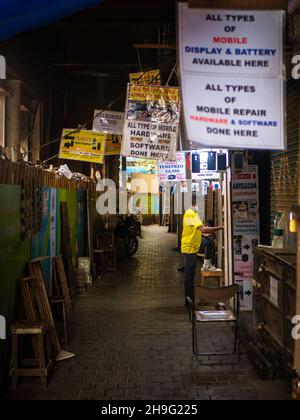 MUMBAI, INDIA - October 2, 2021: Street shop vendor with injured leg arranging stuff at the shop Stock Photo