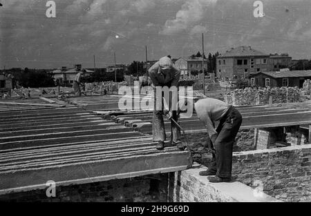 Warszawa, 1948-06. Budowa osiedla Warszawskiej Spó³dzielni Mieszkaniowej (WSM) przy alei Niepodleg³oœci w dzielnicy Mokotów. Nz. uk³adanie belek stropowych. as  PAP    Dok³adny dzieñ wydarzenia nieustalony.      Warsaw, June 1948. Construction of a settlement of the Warsaw Building Association (WSM) on Niepodleglosci Avenue in the Mokotow district. Pictured: workers laying ceiling beams.  as  PAP Stock Photo