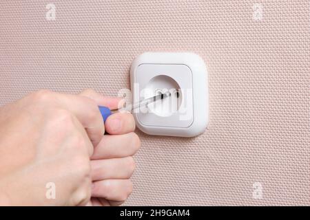 Socket repair, screw screw with a screwdriver to secure socket Stock Photo