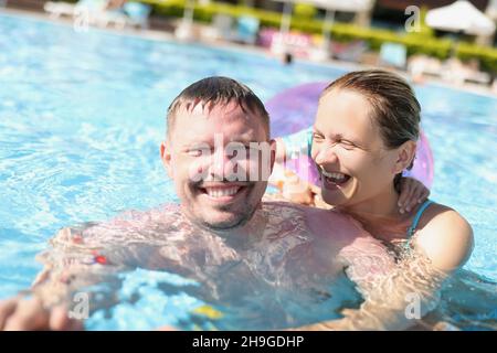 Cheerful couple posing for picture in swimming pool in luxury resort Stock Photo