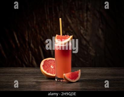 Grapefruit juice in a glass on the table. Refreshing summer drink Stock Photo