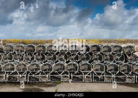 Lobster crab pots stacked on the North Quay in the working Newquay Harbour in Cornwall. Stock Photo