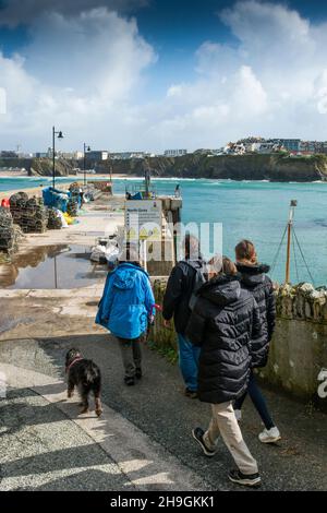 A family of holidaymakers and their dog walking to the North Quay in the picturesque working harbour in Newquay in Cornwall. Stock Photo
