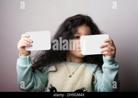Little girl portrait holding two flash cards in hands, preschooler educational material learning objects . path selection included. Stock Photo