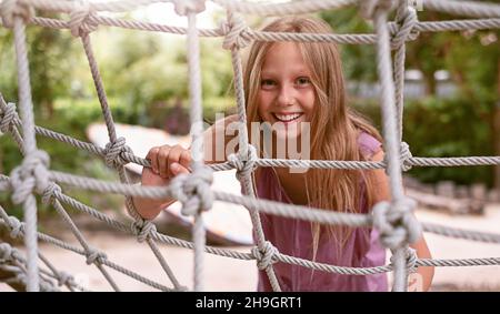 teenager girl on the playground on the rope ladder Stock Photo