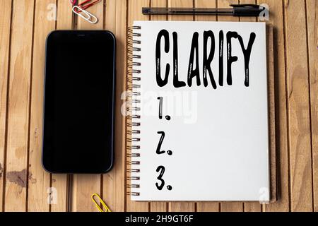 Text sign showing Clarify. Business approach Make a statement or situation less confused and more comprehensible Empty Open Journal Beside Mobile With