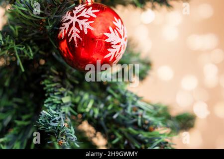 red christmas ornament on the tree. defocus lights on the background Stock Photo